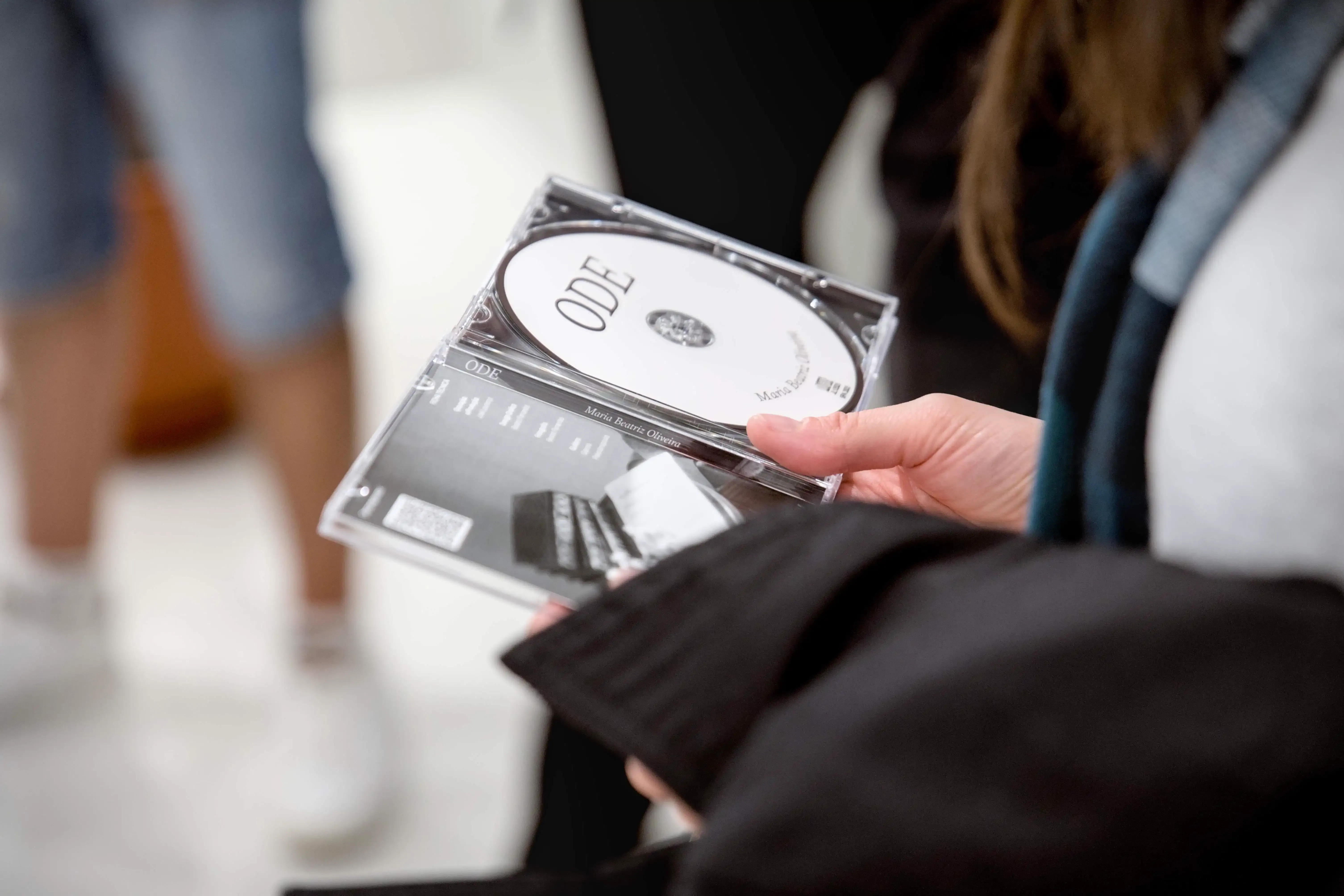 Caixa de um CD aberta. Lê-se "ODE" no CD.